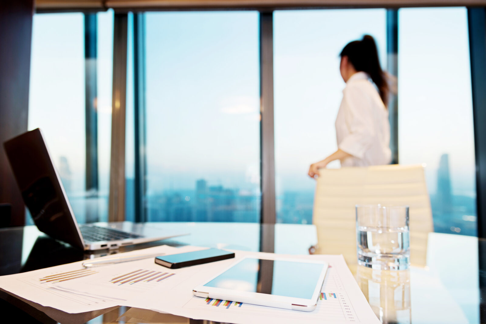 Executive contemplating strategic decisions at office window